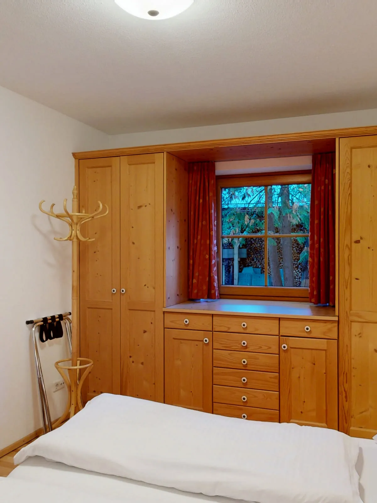 Helles Schlafzimmer mit Holzregalen und Kunst an der Wand