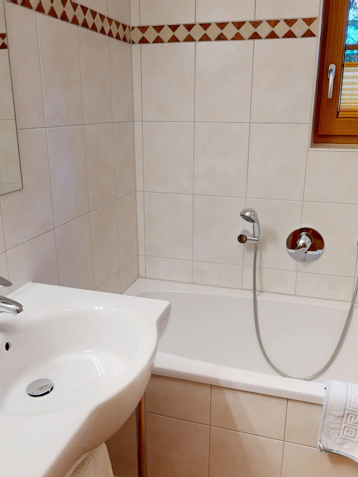 Badezimmer mit Waschbecken, Badewanne und Spiegel