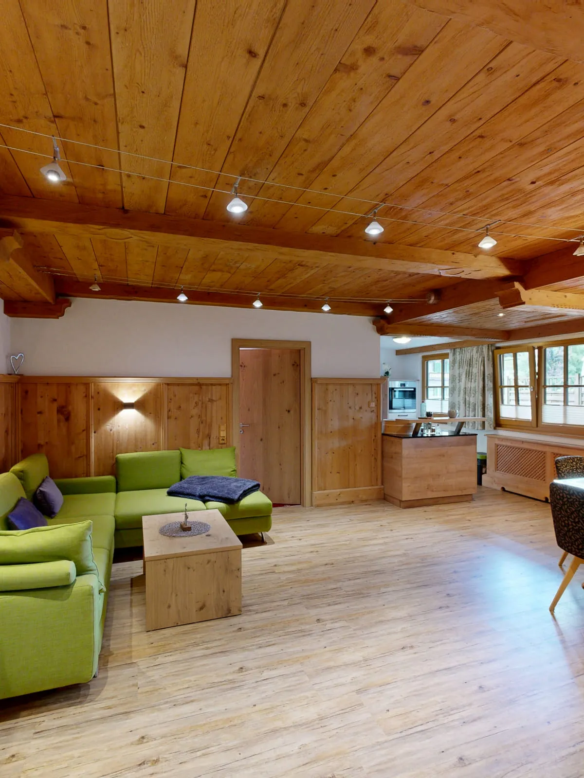 Helles Zimmer mit Holzwänden und Möbeln in grün und braun
