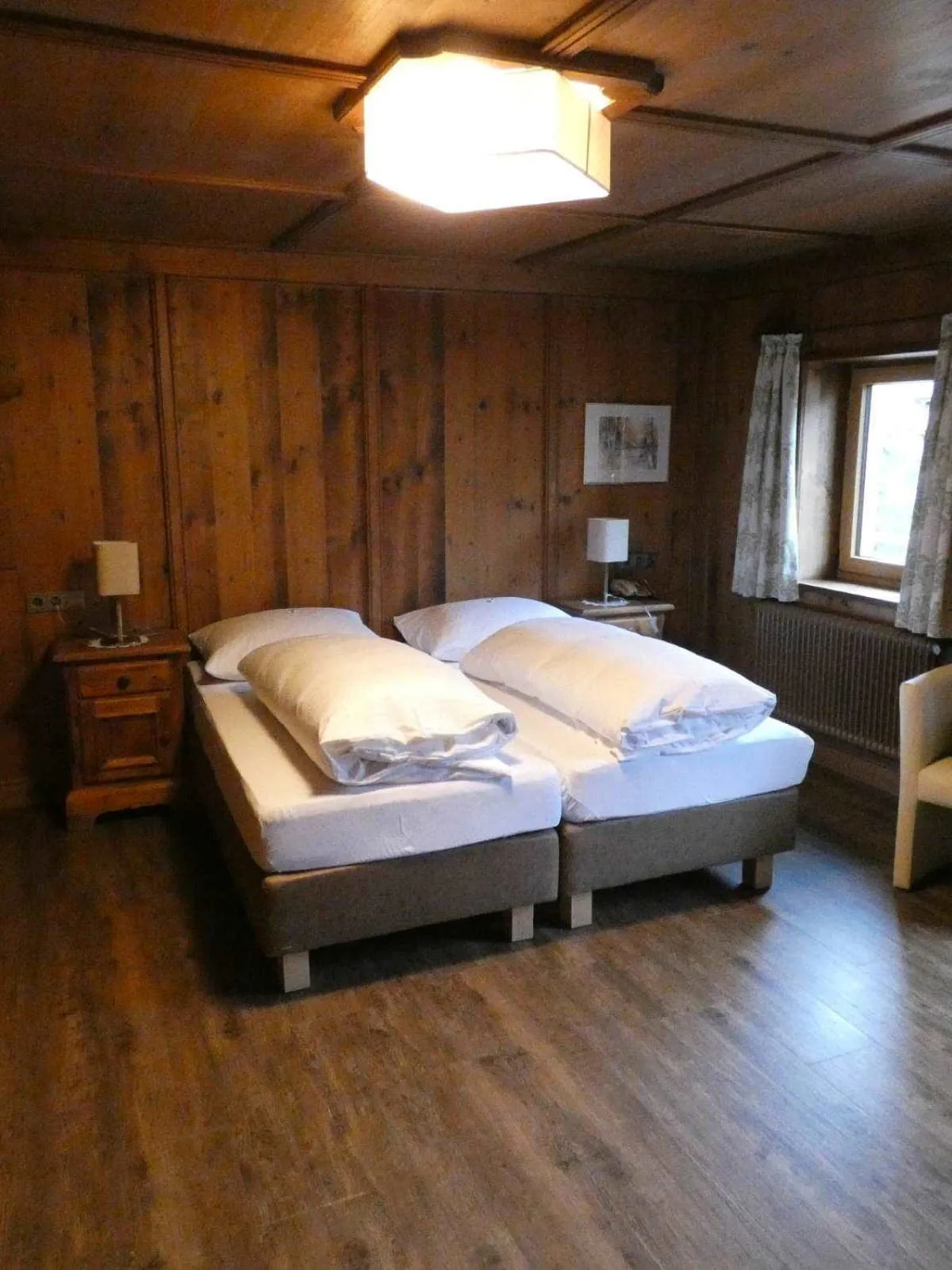 Holzverkleideter Raum mit zwei Betten und einem Stuhl
