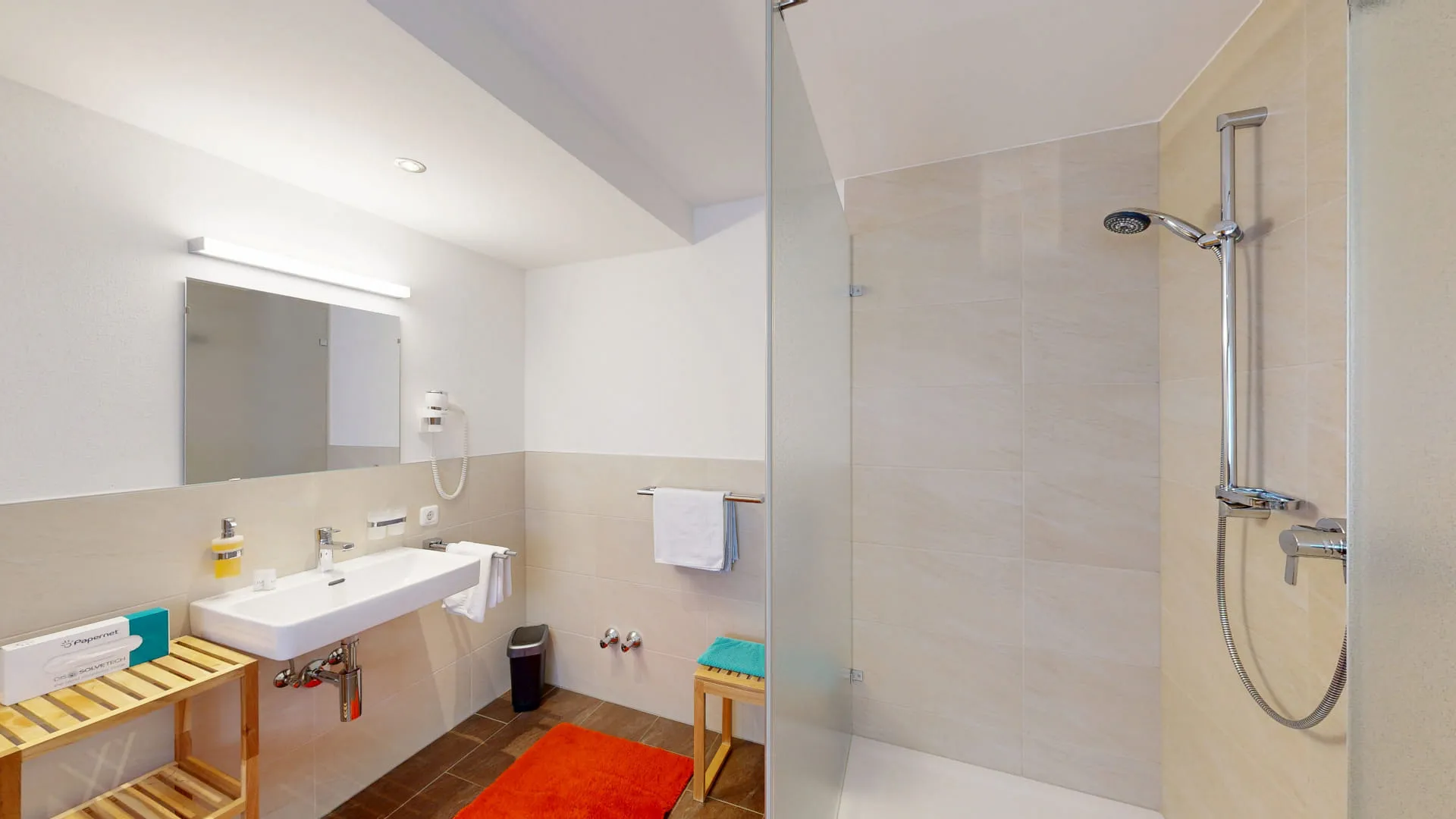 Moderne Badezimmeransicht mit Dusche, Waschbecken und Holzregal