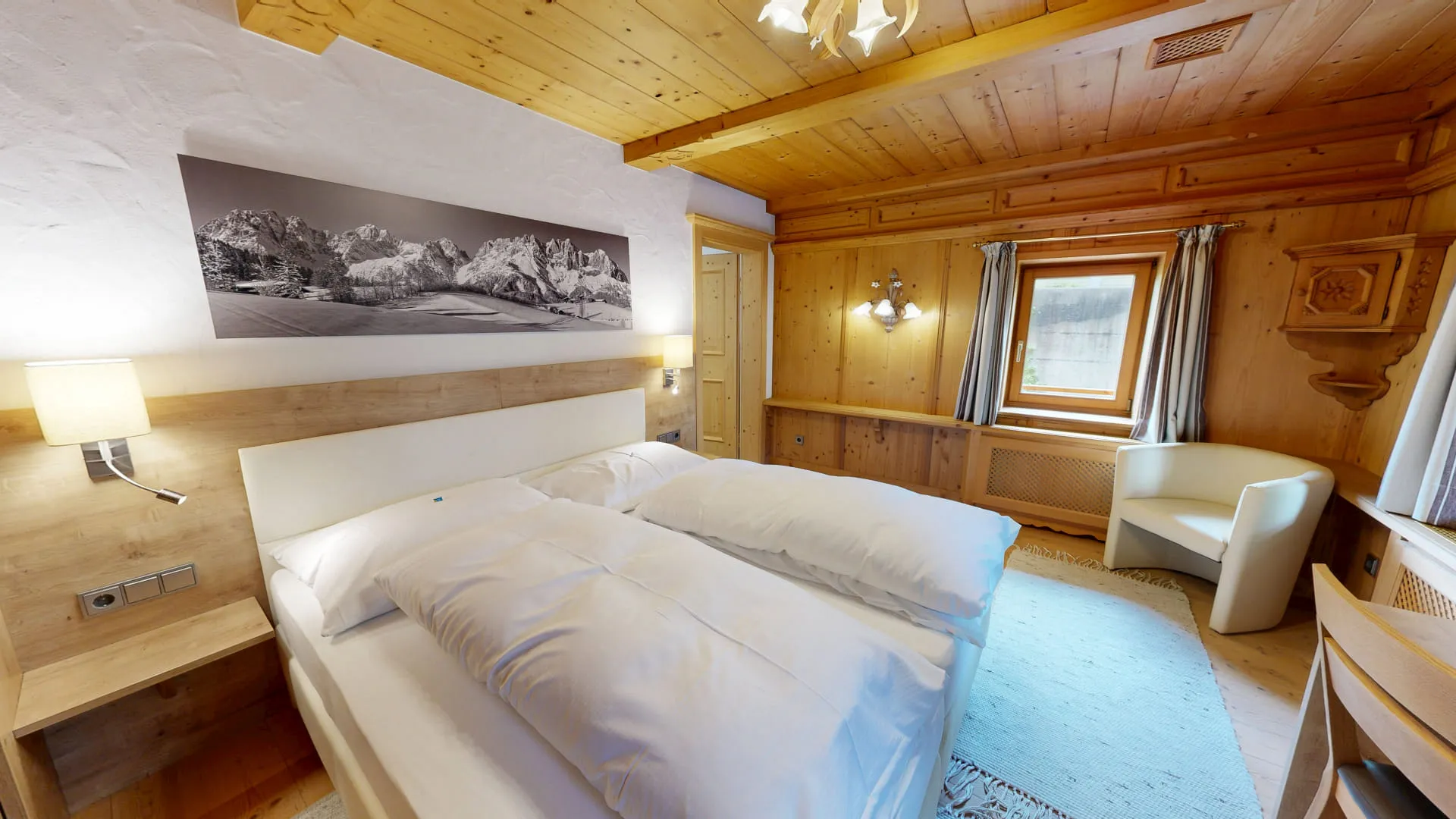 gemütliches Schlafzimmer mit zwei Betten, Holzdecke und Fensterblick